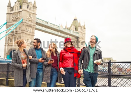 Group of best friends having fun on city street. Group of student people walking through city park together, near of  bridge. Travel and friendship concept - Image