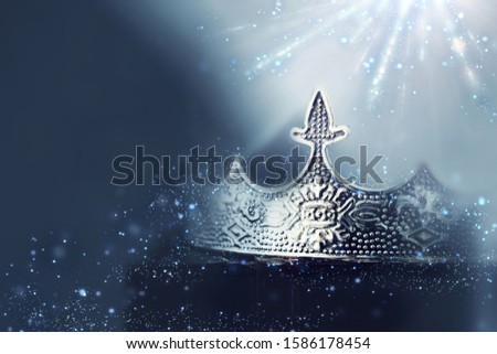 mysterious and magical photo of of beautiful queen/king crown over gothic dark background. Medieval period concept. Glitter sparkle lights