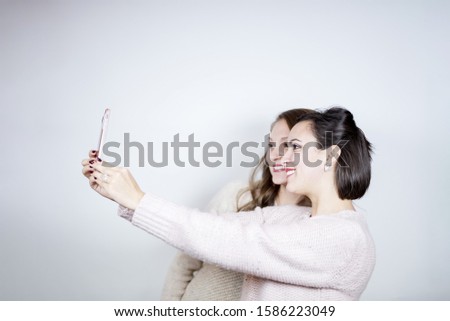 A shallow focus shot of friends taking a selfie with a white background