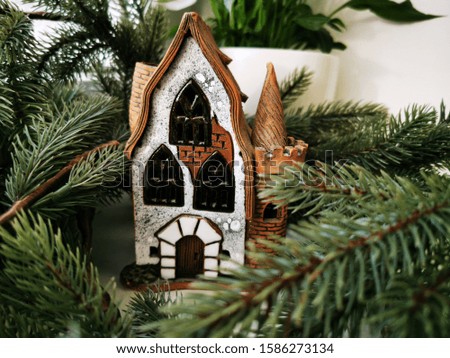 Christmas candlestick, stylized as an old half-timbered German house among spruce branches. Christmas theme. New Year card