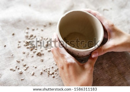 Female hands hold a bowl for casting clay products. Shaped method for making clay dishes. Handwork. Pottery making