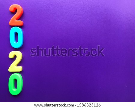 2020 number with color numbers on a purple violet background with free space on the right