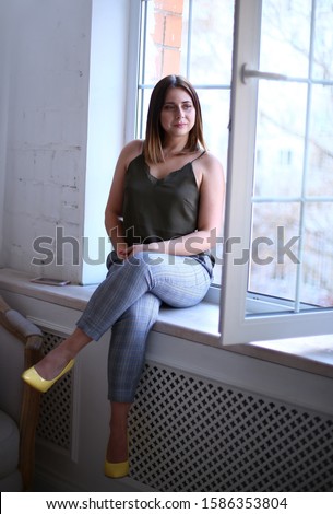 Stylish young beautiful girl with dark hair in a good mood