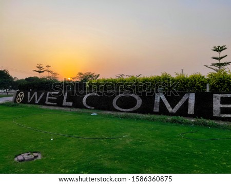 sunset scene with welcome note and grass