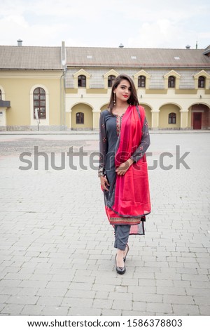 An Indian girl stands on the street of the city of Ivano-Frankivsk. Girl in traditional Indian clothing, salwar kameez. Royalty-Free Stock Photo #1586378803