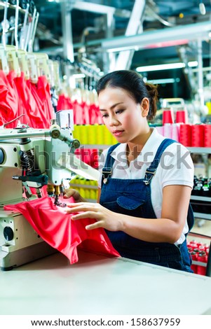Seamstress or worker in a factory sewing with a industrial sewing machine, she is very accurate