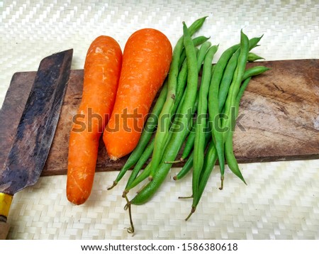 carrots and beans on bamboo matting