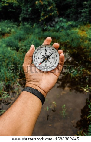 HOLDING COMPASS IN HAND FOR FINDING DIRECTION Royalty-Free Stock Photo #1586389645