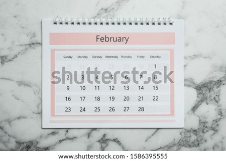 February calendar on marble background, top view