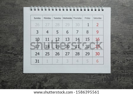 Paper calendar on grey stone background, top view