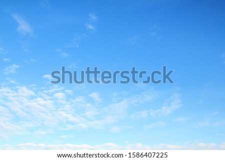 Blue sky with slight white clouds, sunny day sky background. Royalty-Free Stock Photo #1586407225