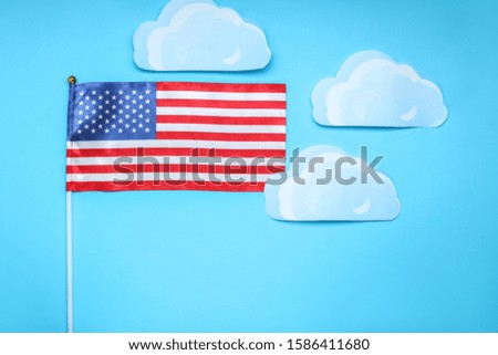 USA flag and paper clouds on color background