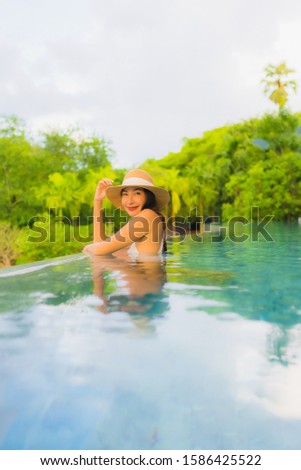Portrait beautiful young asian women happy smile relax around outdoor swimming pool in hotel resort