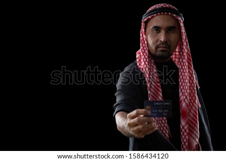 Arab man hand holding credit card on black background