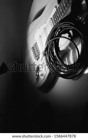 electric guitar and instrumental cable closeup . black and white