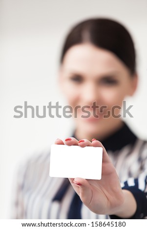 Smiling businesswoman showing and handing a blank business card
