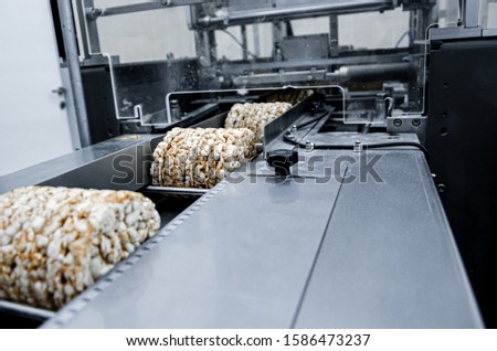 conveyor automatic tape for the production of useful whole-grain extruder crispbread. packing organic multi-barley briquetted crispbread on factory