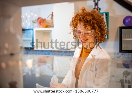 Scientist working in laboratory. Life scientists researching in laboratory. Focused female life science professional pipetting solution into the glass cuvette. Healthcare and biotechnology concept.