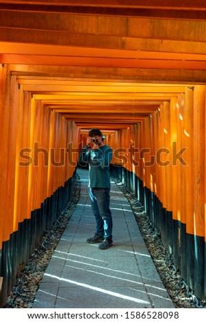 Man taking pictures at Fushimi Inari Shrine. Kyoto, Japan