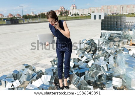 Young caucasian woman in office clothes with elements of components for structures, metal profile