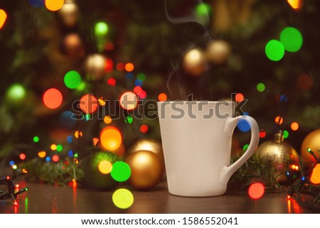 A light mug without a picture - with place for your text - on a New Year's background with shiny balls and lights of garlands.