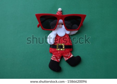 close up Santa Claus wearing red glasses on a green background. Christmas and New Year