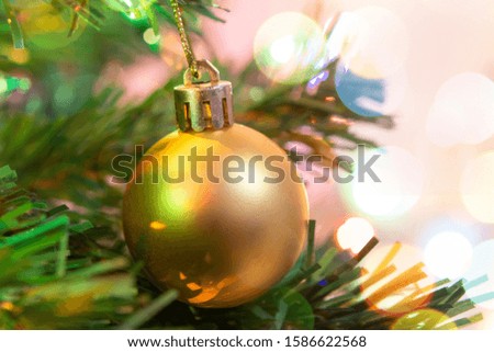 Christmas decoration. Hanging gold balls on pine branches Christmas tree garland and ornaments over abstract bokeh background with copy space

