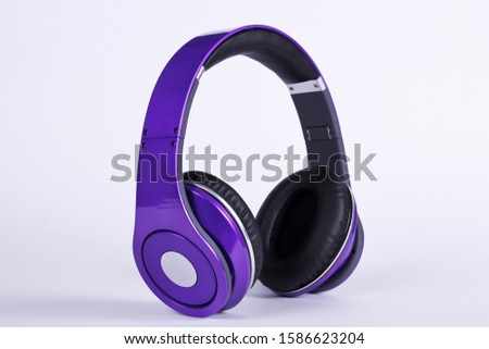 Stylish modern purple headphones on light background.