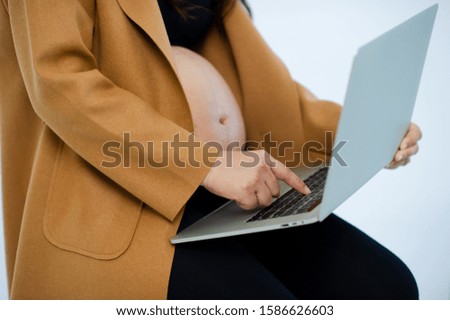 Pregnant and laptop are studying to raise their children.