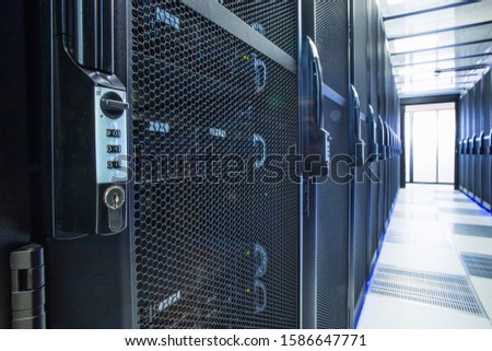 Security lock on mainframe computers in centre of data center server farm Royalty-Free Stock Photo #1586647771