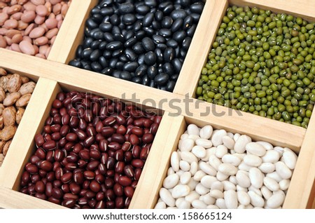 black, mung, white, and light red beans in wooden tray 