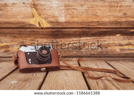 Retro camera on the old wood  background, copy-space.