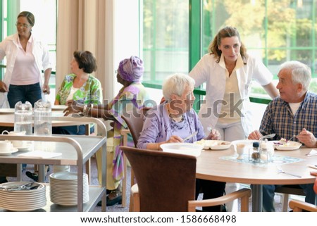 A group of senior people having lunch together in a retirement home Royalty-Free Stock Photo #1586668498