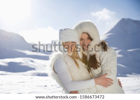 Portrait of young women in winter coats and fur standing in mountains