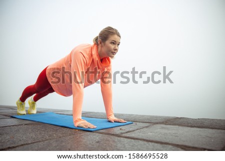 Beautiful young woman having morning gymnastics outdoors stock photo. Website banner