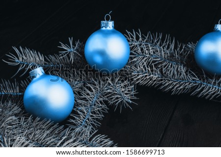 Christmas or New Year toy decorations golden balls and fur tree branch rustic on wooden background, top view, copy space. Color of the year 2020 classic blue. Fashionable pantone color trend concept