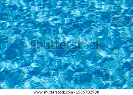 Abstract natural blurred blue background. Pool water texture background. Reflection of sunlight in the pool water. Horizontal.Concept of sports and recreation.