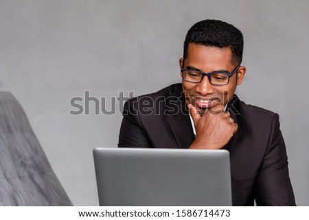 Portrait of a positive and natural african american male businessman in formally attire posing over gray background. Successful business people concept. Advertising space