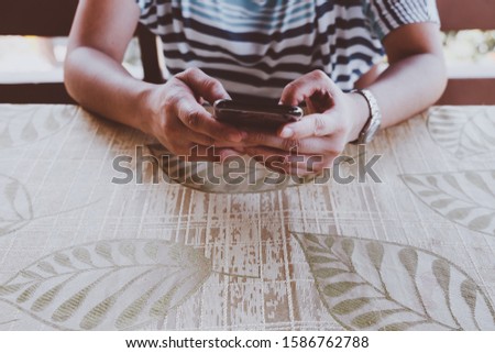Woman's hands holding a mobile phone. Selective focus. Copy space. Toned picture.