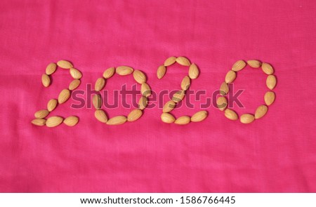 create 2020 with almonds on pink background