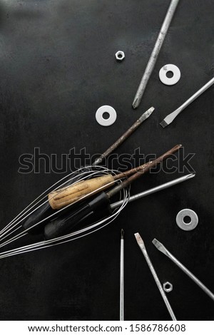 Many screwdrivers are located in the creative composition. Metal tools in the image of a fish caught in a fishing net. Tools. Workshop. Steel tools decor.