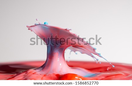 Baby blue and pink colored milk splashes together and is frozen in space with high speed photography