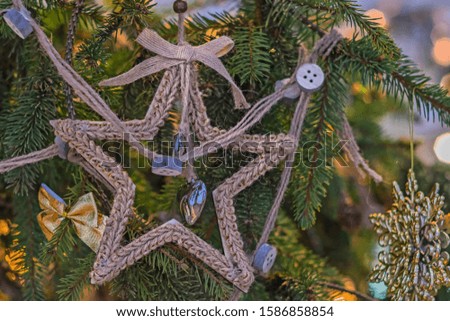A Christmas tree is decorated with beads and a star. Multi-colored garlands on a blurry background. Happy New Year
