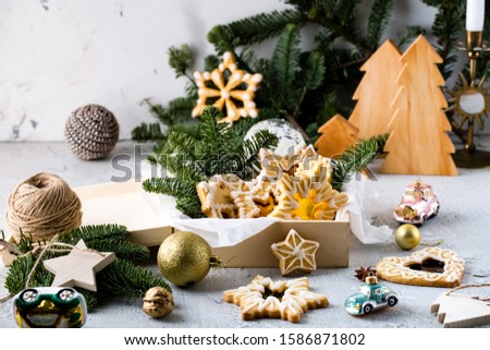 Christmas home made cookies in wooden gift box decorated with sugar icing in wooden gift box in festive setting on white background with bokeh lights, selective focus 