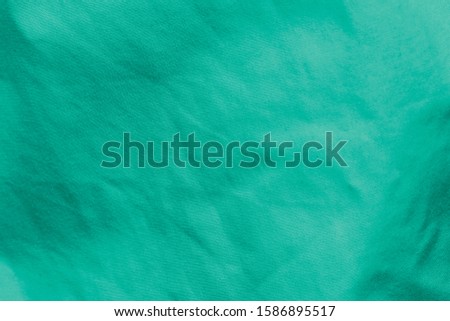 texture of the unevenly lit fabric of cyan