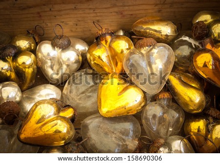 Christmas heart shaped vintage baubles in wooden box. Old times idea. Shadowed angles.