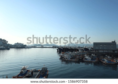 A landscape picture of a korean seaport(A text on white building : cold storage)