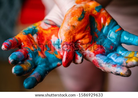 Closeup of woman hands dirty with acrylic paint. Creative finger painting.