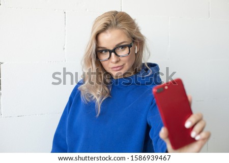 Smiling woman in glasses makes selfie.