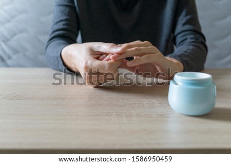 Woman doing the manicure. Removing the polish and putting on the cream. Woman that care his hands. Style concept.